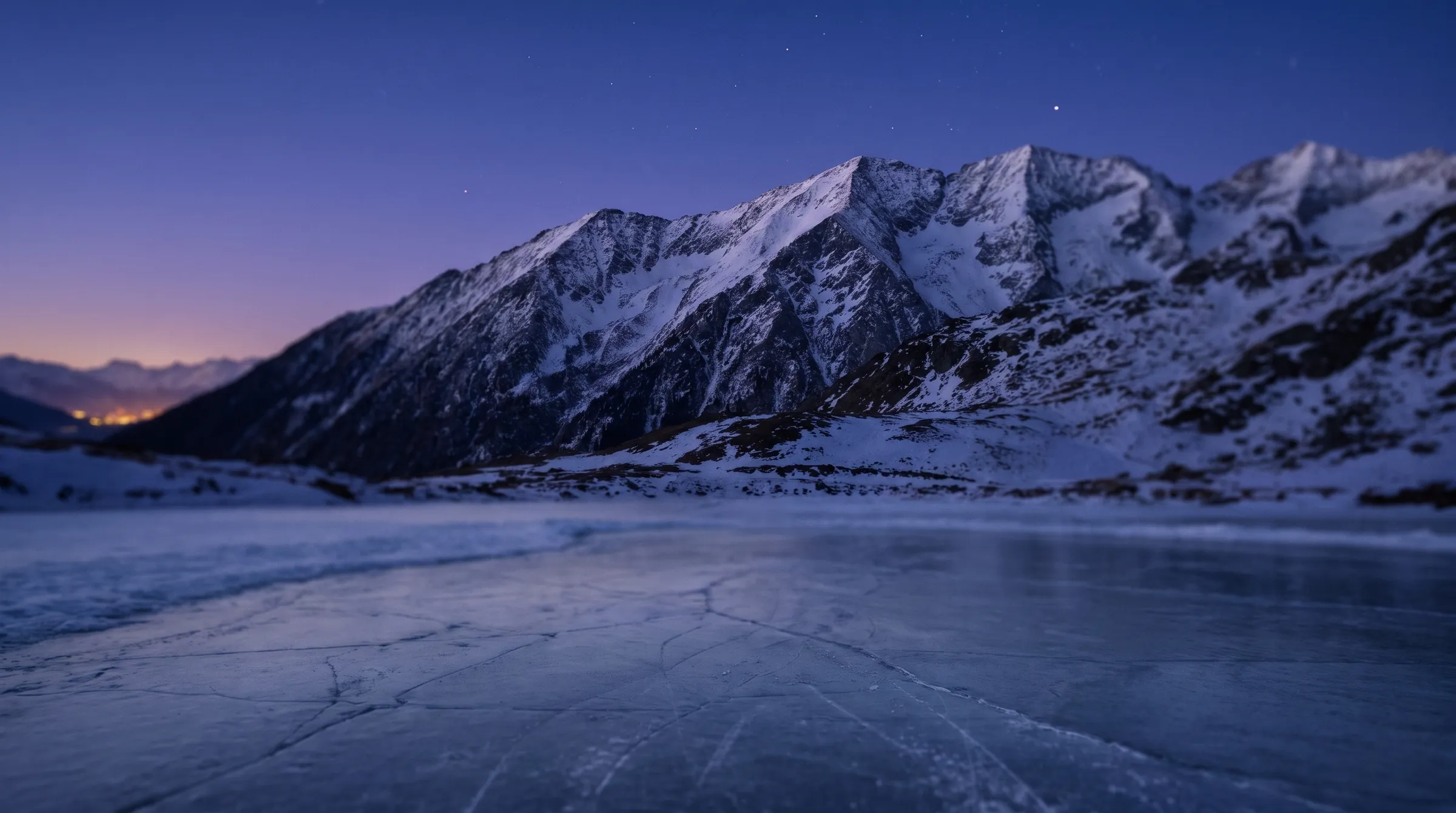 The Rocky Mountains above a frozen pond at blue hour